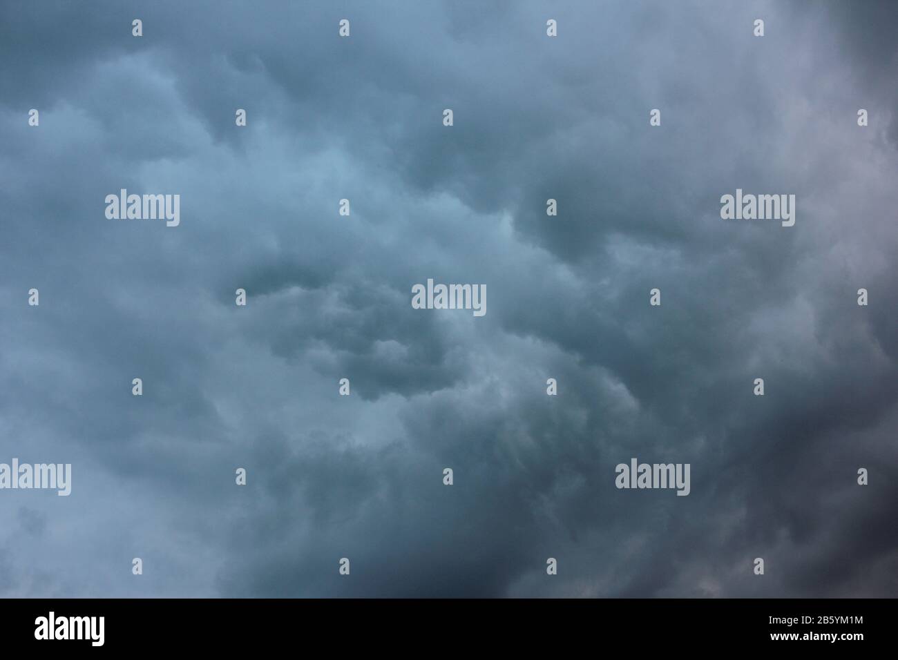 Verschwommener dramatischer Himmelshintergrund. Aufregende dunkle stürmische Wolken vor Regen Stockfoto