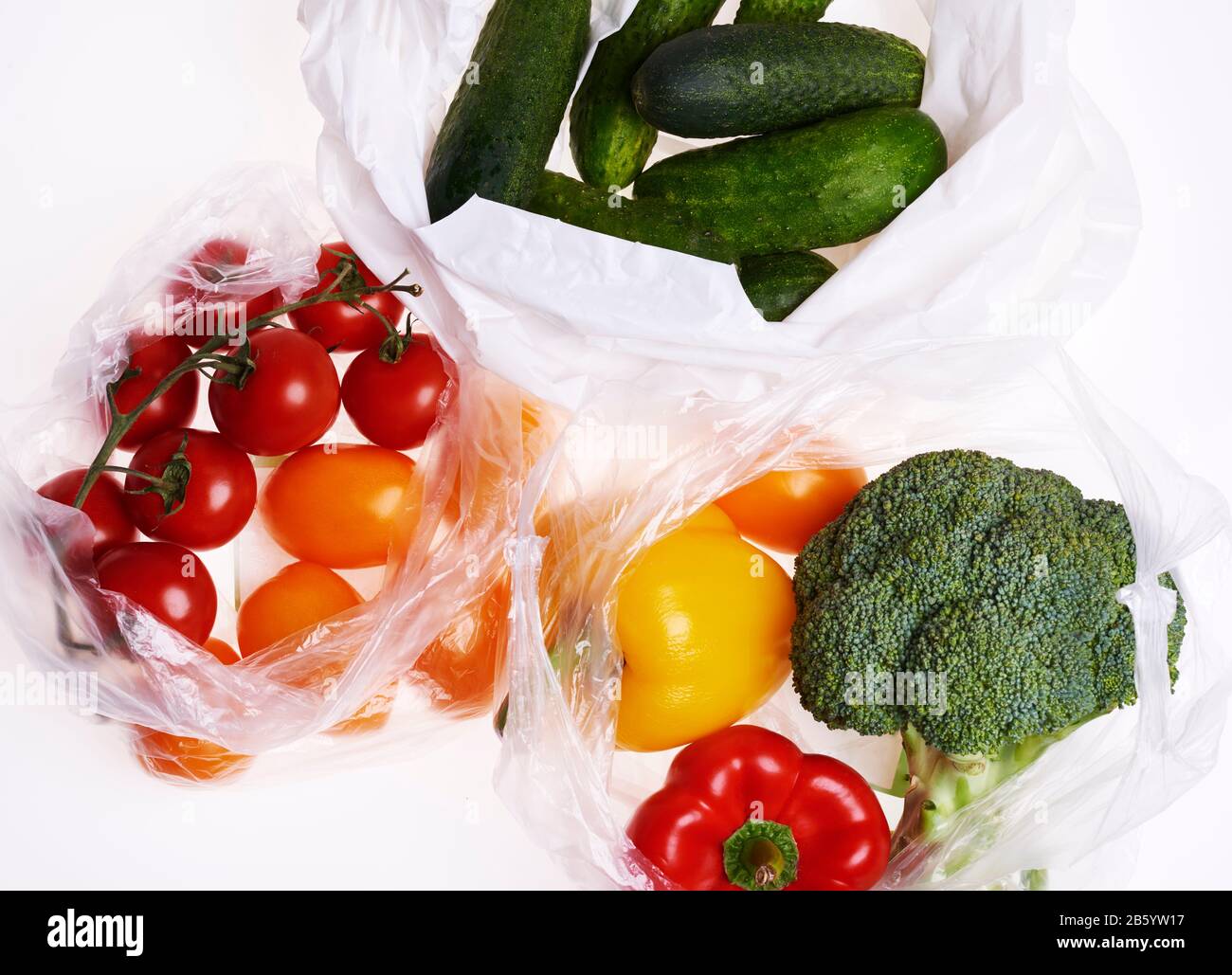 Drei Plastiktüten Gemüse auf weißem Hintergrund Stockfoto