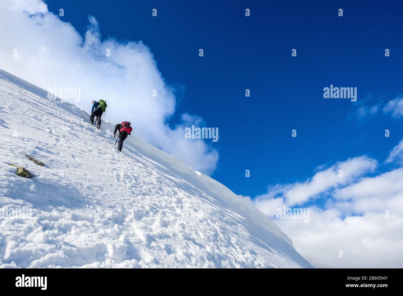 Winterwanderer, die von Der Streifkante bis zum Gipfel von Helvellyn im Lake District National Park, Cumbria, Großbritannien, steil aufsteigen Stockfoto