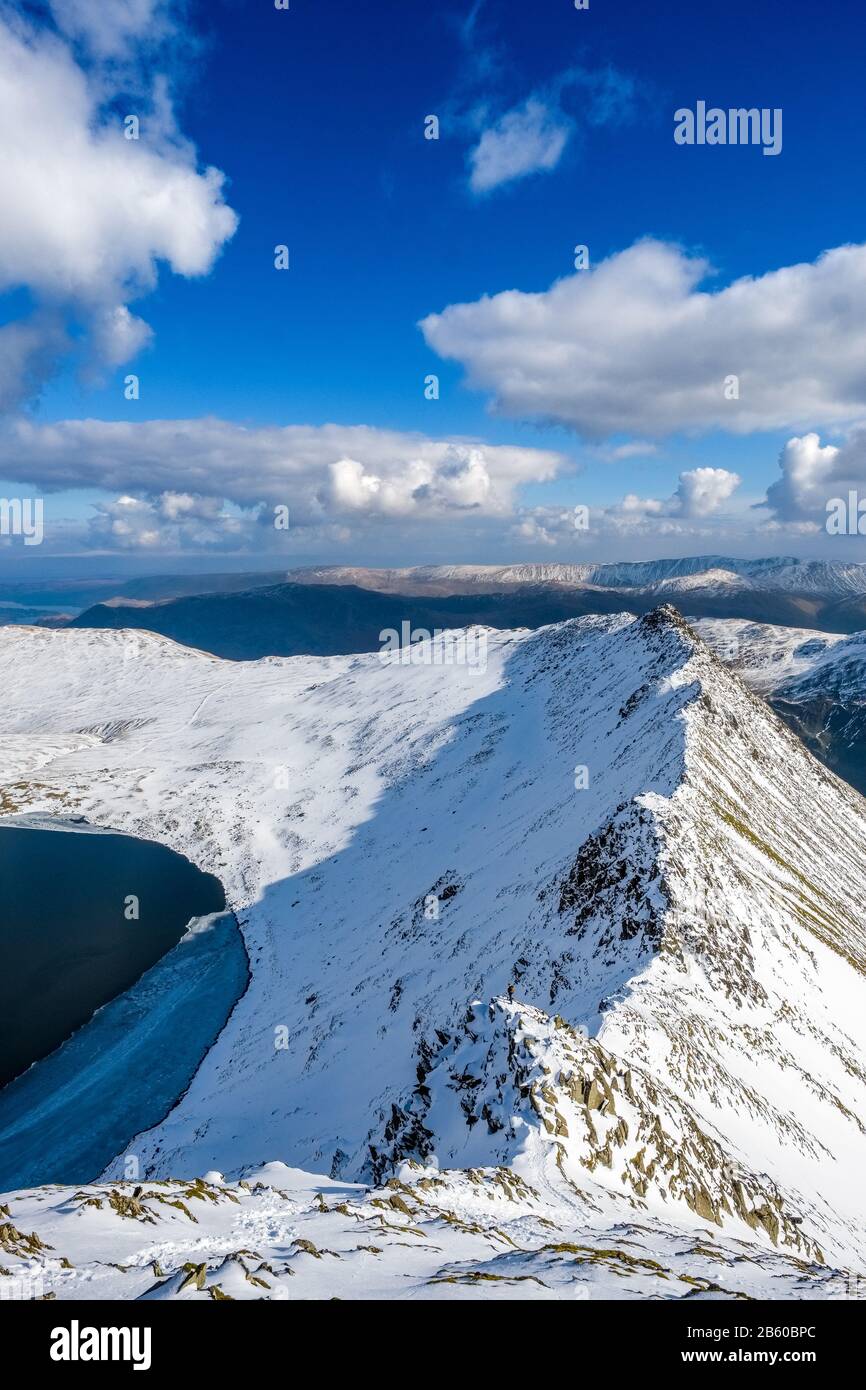 Streifkante auf Helvellyn im Winter. Der Grat ist eine beliebte Herausforderung für Sommergerangel und Winterbergsteigen. Lake District, Stockfoto