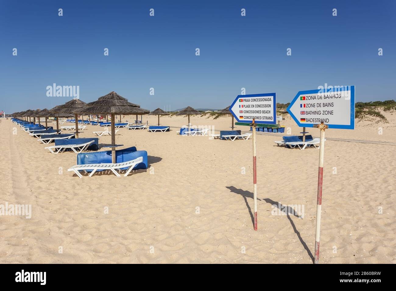 Zeiger auf einen Erholungsbereich zum Sonnenbaden. Sonnenliegen und Sonnenschirme. Portugal Stockfoto