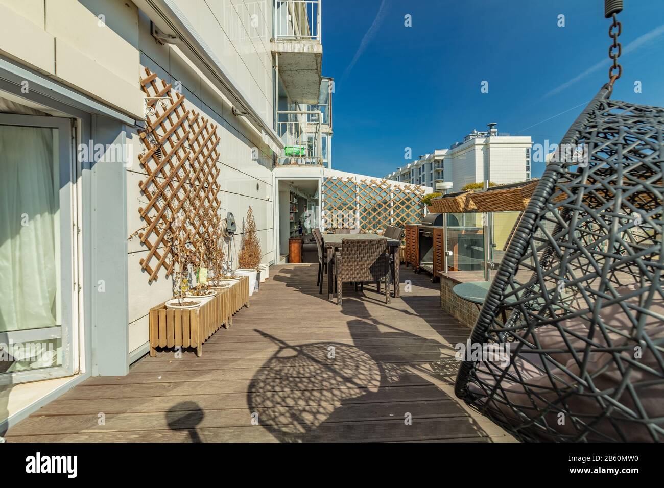 Persönliche Terrasse mit Tisch und Stühlen für die Freizeit im Freien im modernen Apartmentgebäude Stockfoto