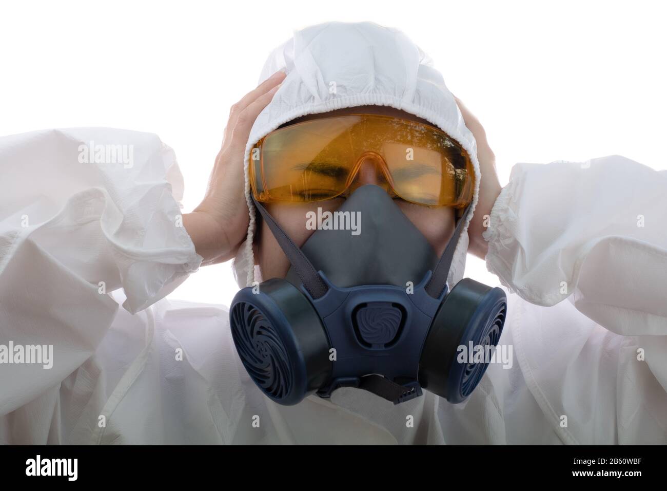 Frau fühlt sich in einer chemischen Schutzkleidung und einer Antigasmaske mit gelben Gläsern am isolierten weißen Hintergrund belastet, Wissenschaftlerin im Sicherheitsanzug, Stockfoto