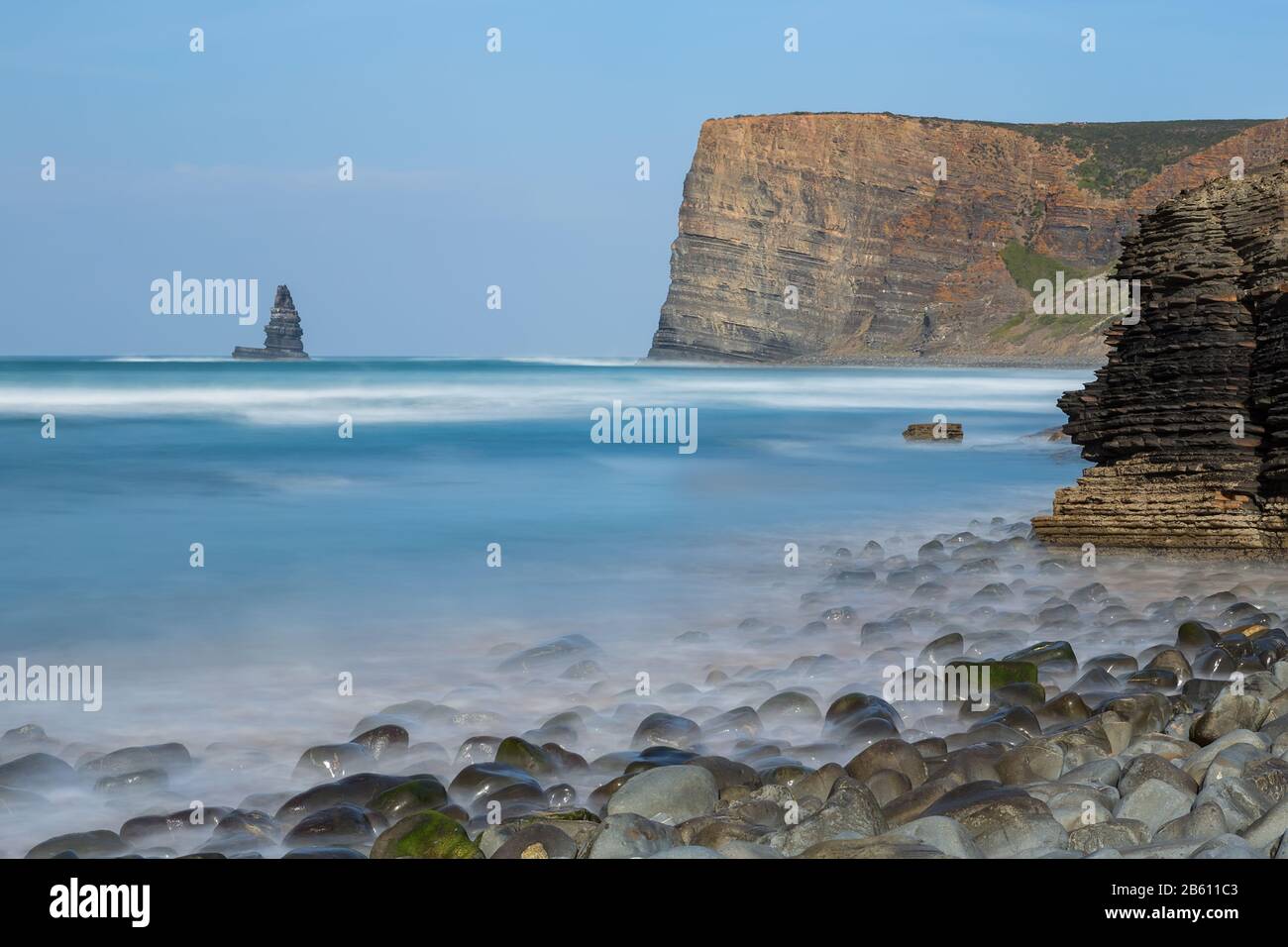 Steinnadel aus Meereslandschaft. Portugal Aljezur Algarve, Langzeitbelichtung. Stockfoto