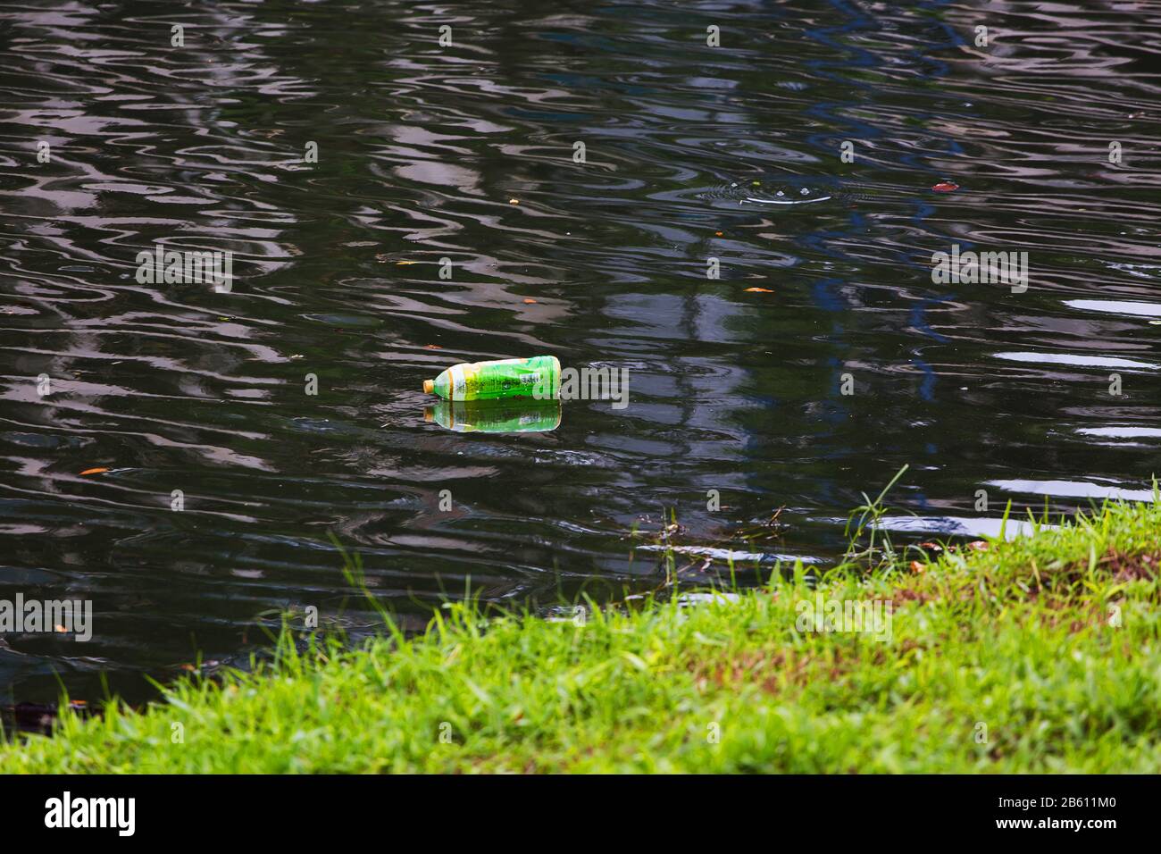 Eine Plastikflasche, die auf dem sauberen Fluss schwimmt, braucht Technologie, um Menschen zu bekämpfen, die das Abwasser ins Wasser werfen. Stockfoto