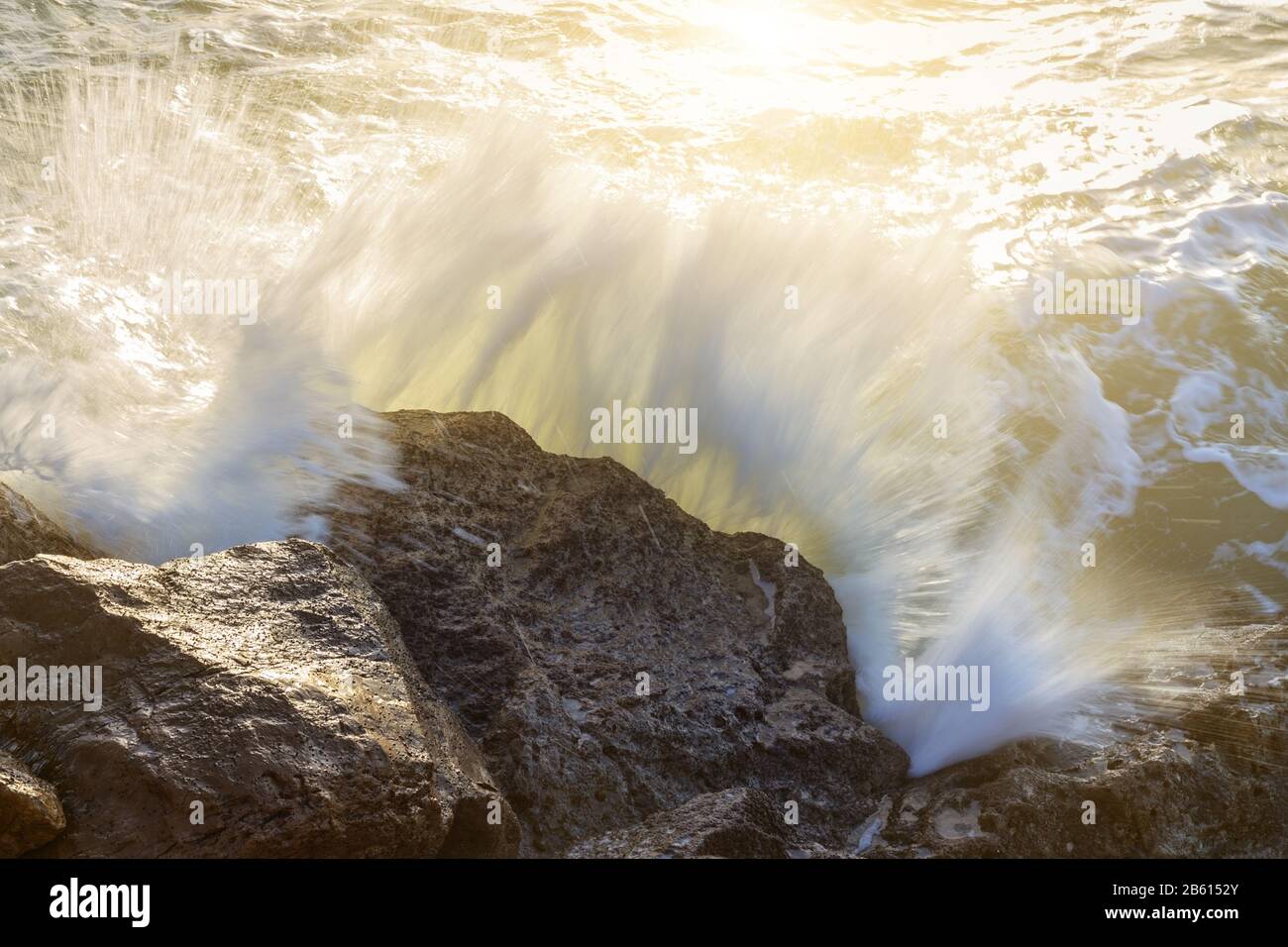 Wellen Sie auf die Sonnenfreiheit, die auf den Felsen bricht. Nahaufnahme. Stockfoto