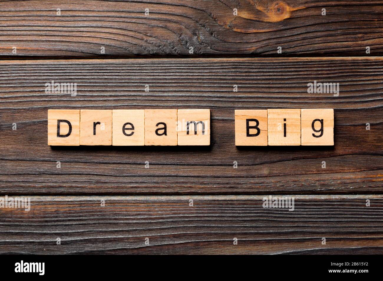 Traum großes Wort auf Holzklotz geschrieben. Träumen Sie großen Text auf Holztisch für Ihr Desing, Top-View-Konzept. Stockfoto