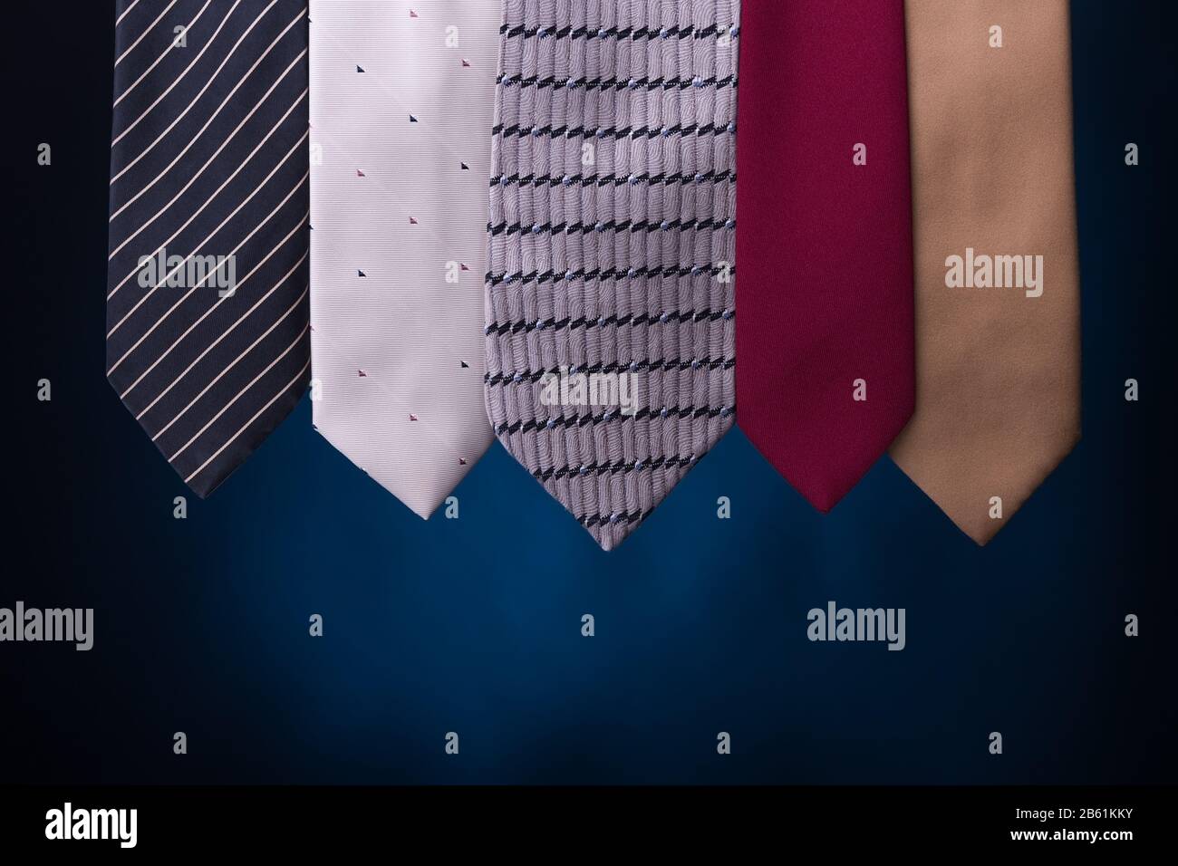 Set aus mehrfarbigen Krawatten in Herrenmode. Auf blauem Hintergrund. Stockfoto