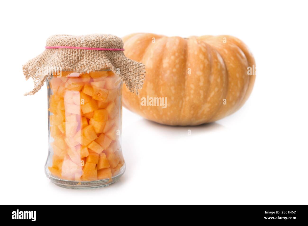 Kürbisse in einem Glasbecher gewürfelt. Auf dem Hintergrund des Gemüses. Stockfoto