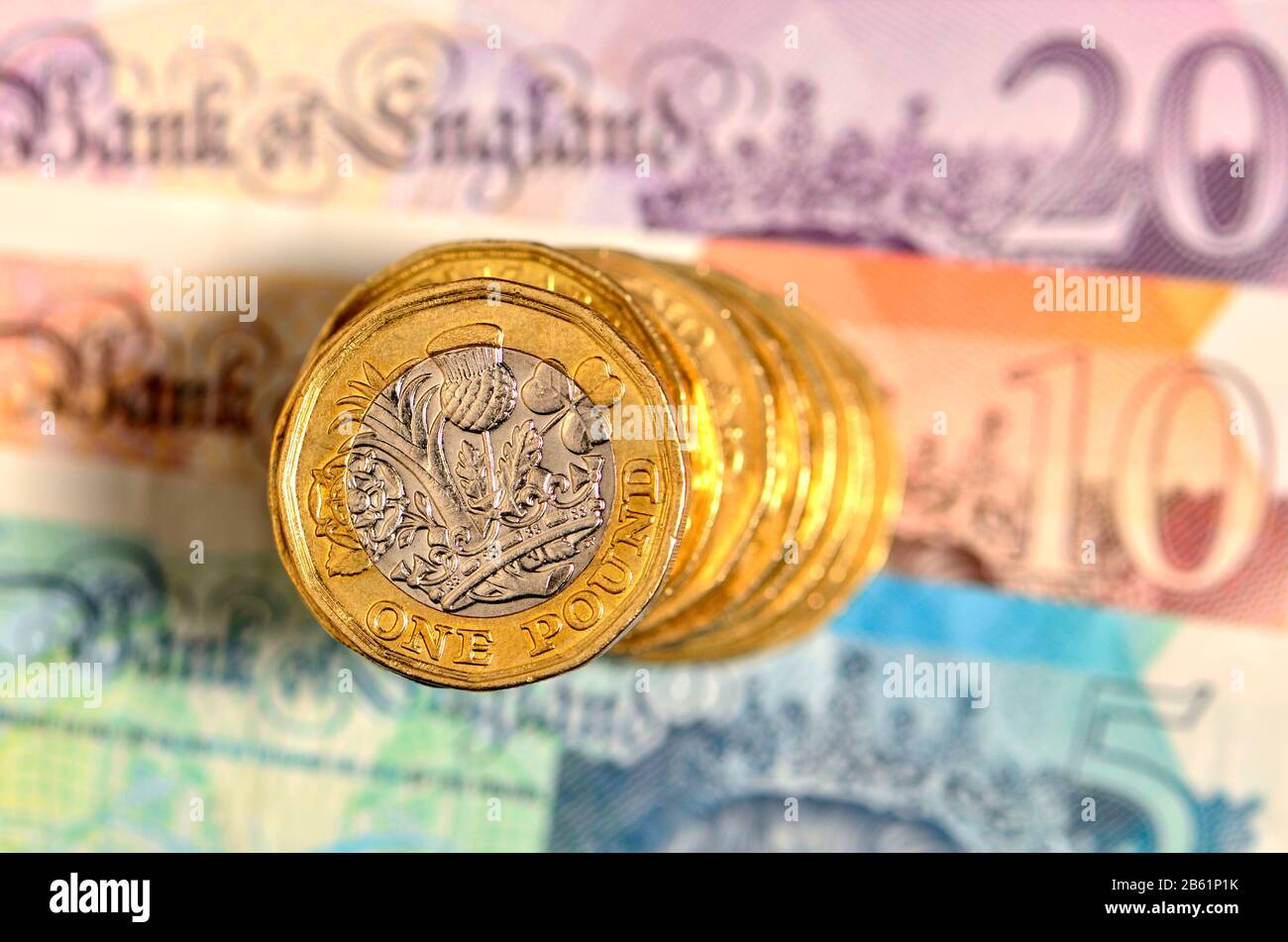 Stapel britischer Pfund-Münzen auf Banknoten Stockfoto