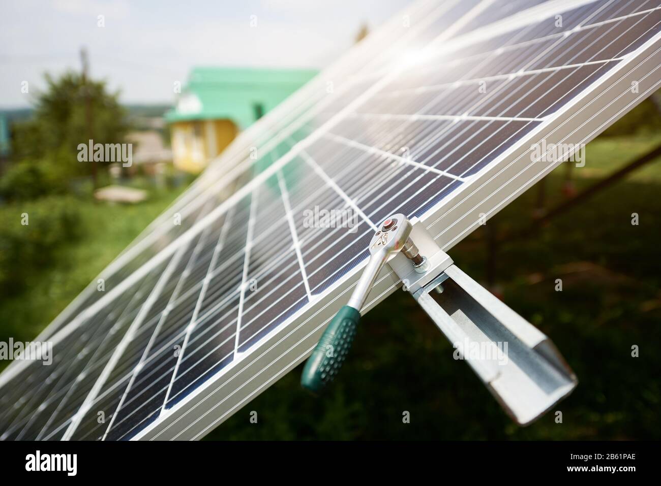 Alternatives Konzept für Sonnenenergie. Sonnenkollektoren in der Nähe des Hauses mit Schraubenschlüssel auf Himmelshintergrund. Ökologiekonzept. Wissenschaftlicher Hintergrund. Alternatives Konzept für Sonnenenergie. Stockfoto