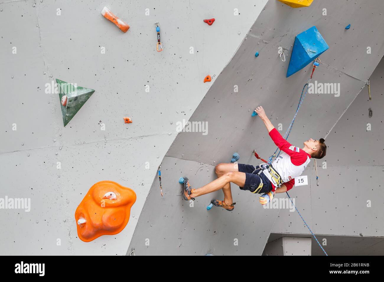 Mai 2017, UFA, RUSSLAND: Ein Mann klettert auf eine künstliche offene Felswand mit niedrigerem Belay Stockfoto