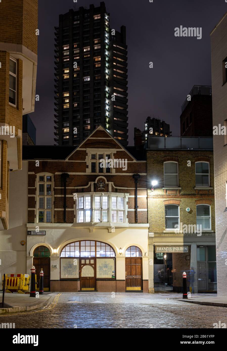 London, England, Großbritannien - 25. Februar 2020: Der hohe Brutalist Lauderdale Tower des Barbica-Anwesens ragt über Büros im traditionellen Tiefhaus Cle Stockfoto