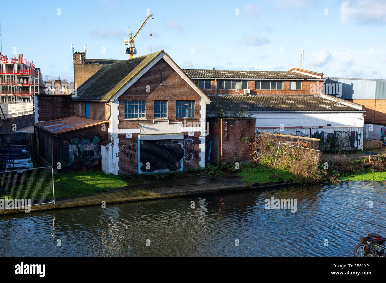 London, England, Großbritannien - 17. Januar 2020: Leichte Industriewerkstätten und Lagerhallen stehen am Ufer des Flusses Lea Navigation, unter den Bauen Stockfoto