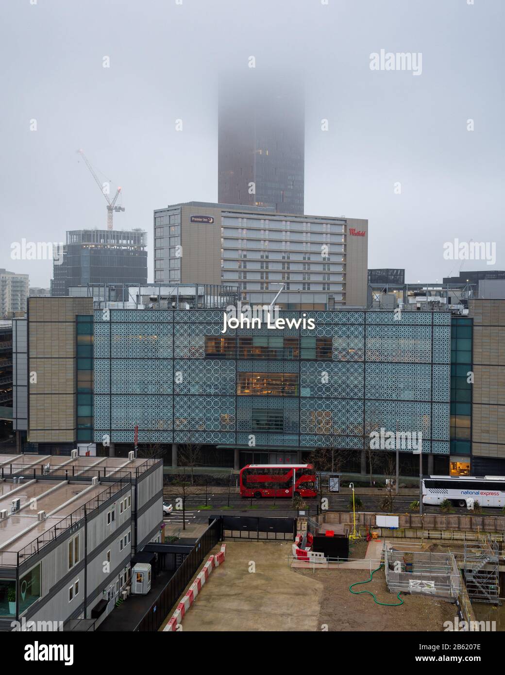 London, England, Großbritannien - 31. Dezember 2019: Das hochaufragende Stratford Hotel verblasst in einen nebligen Himmel über dem John Lewis Kaufhaus und dem Westfield Shop Stockfoto
