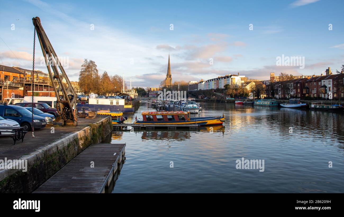Bristol, England, Großbritannien - 29. Dezember 2019: Abendsonne scheint auf dem Turmspitze der St. Mary Redcliffe Kirche und der historischen Docks von Bristol. Stockfoto