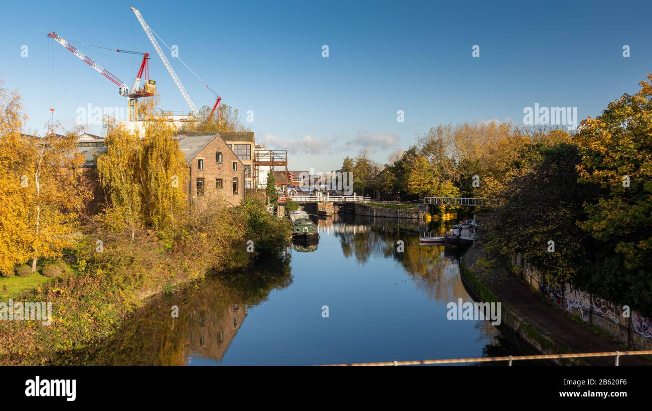 London, England, Großbritannien - 18. November 2019: Herbstsonne auf dem Fluss Lea Navigation und Lichtindustriegebäude und neue Bauwohnungen in der Fi Stockfoto