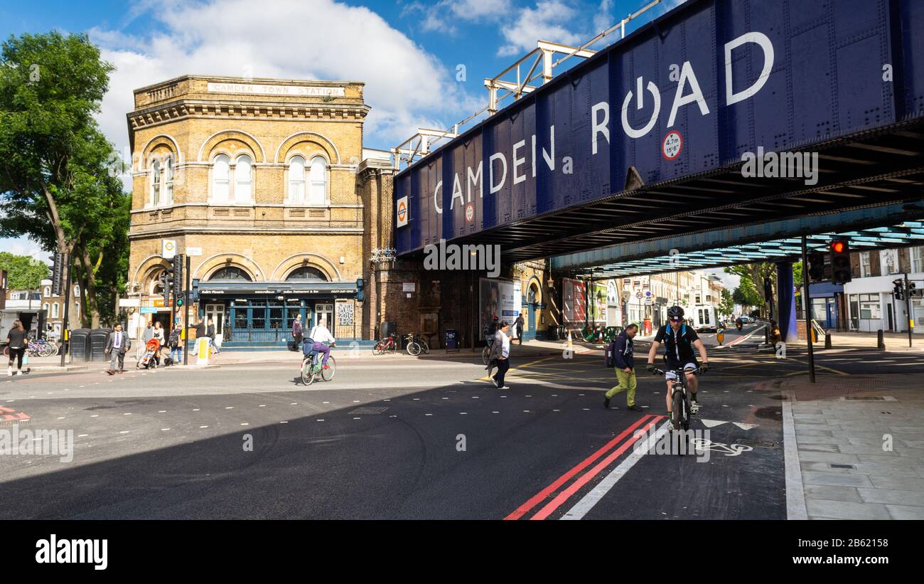 London, England, Großbritannien - 21. Juni 2016: Fußgänger und Radfahrer passieren die Kreuzung von Camden Road und Royal College Street, unterhalb der Londoner Ov Stockfoto