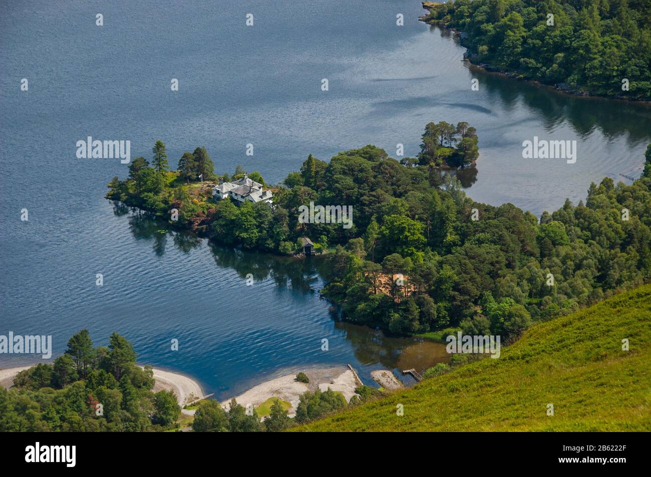 Ein Herrenhaushaus steht in Waldland am Ufer des Derwent Water Lake bei Brandelhow im englischen Lake District, von Catbells Mountain aus betrachtet. Stockfoto