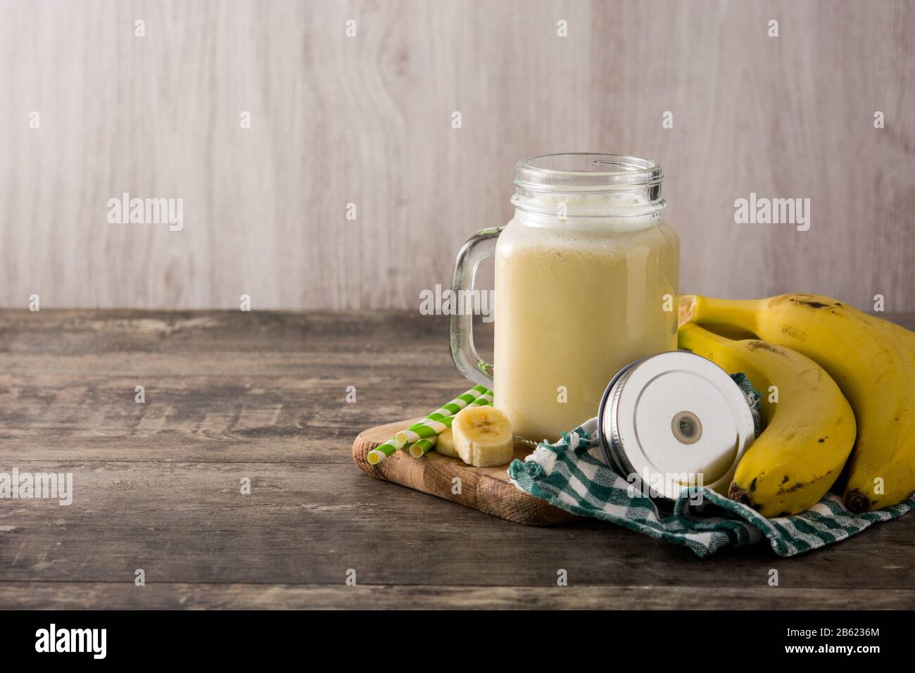 Bananen-Smoothie im Mixbecher auf Holztisch. Kopierbereich Stockfoto