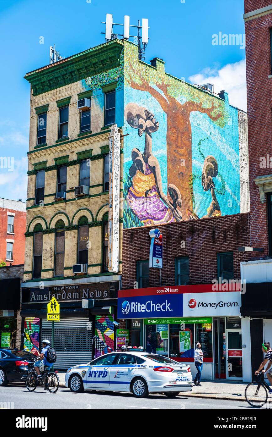 New York City, USA - 4. August 2018: Polizeiwagen mit großem Graffiti auf der Straße geparkt und Menschen in Harlem, Manhattan, New York City, USA Stockfoto