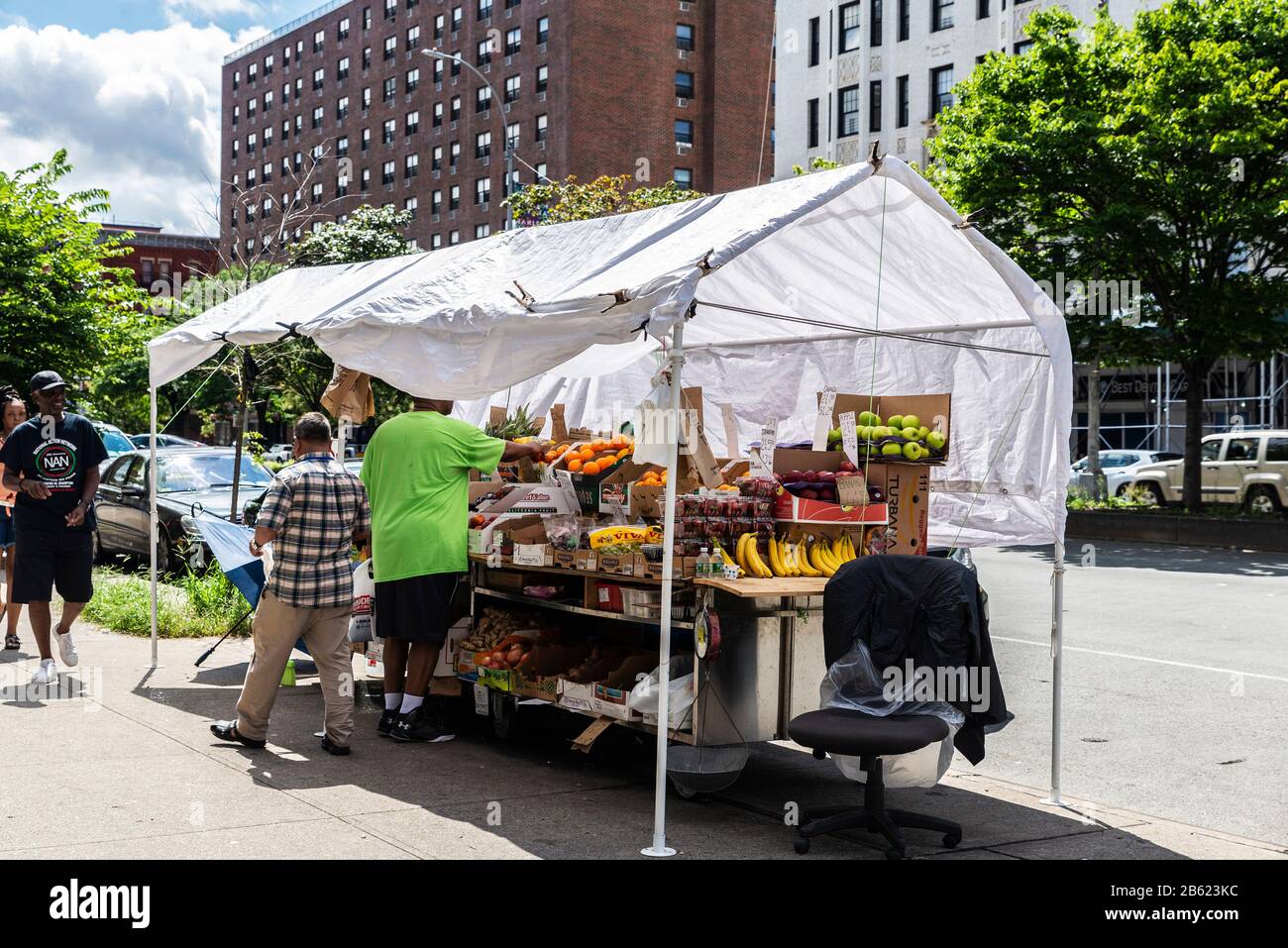 New York City, USA - 4. August 2018: Händler in Ihrem Lebensmittelstall für Obst und Gemüse in Harlem, New York City, USA Stockfoto