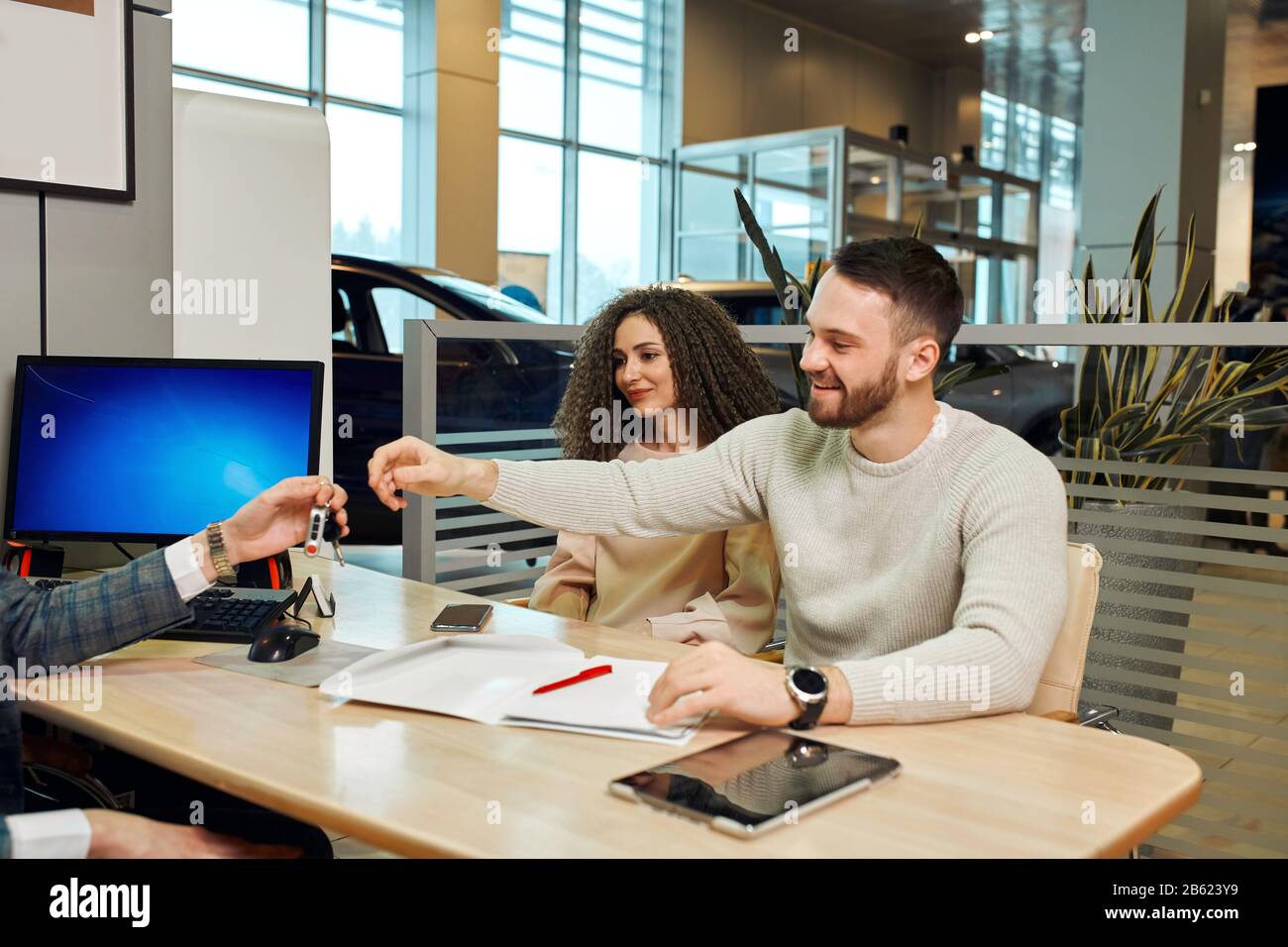 Junge glückliche positive Paare erhalten einen Schlüssel ihres neuen Luxusautos, erfolgreichen Einkaufens, Schnäppchen, Nahaufnahme Foto. Gute Choise.Happiness, Traum ist gekommen Stockfoto