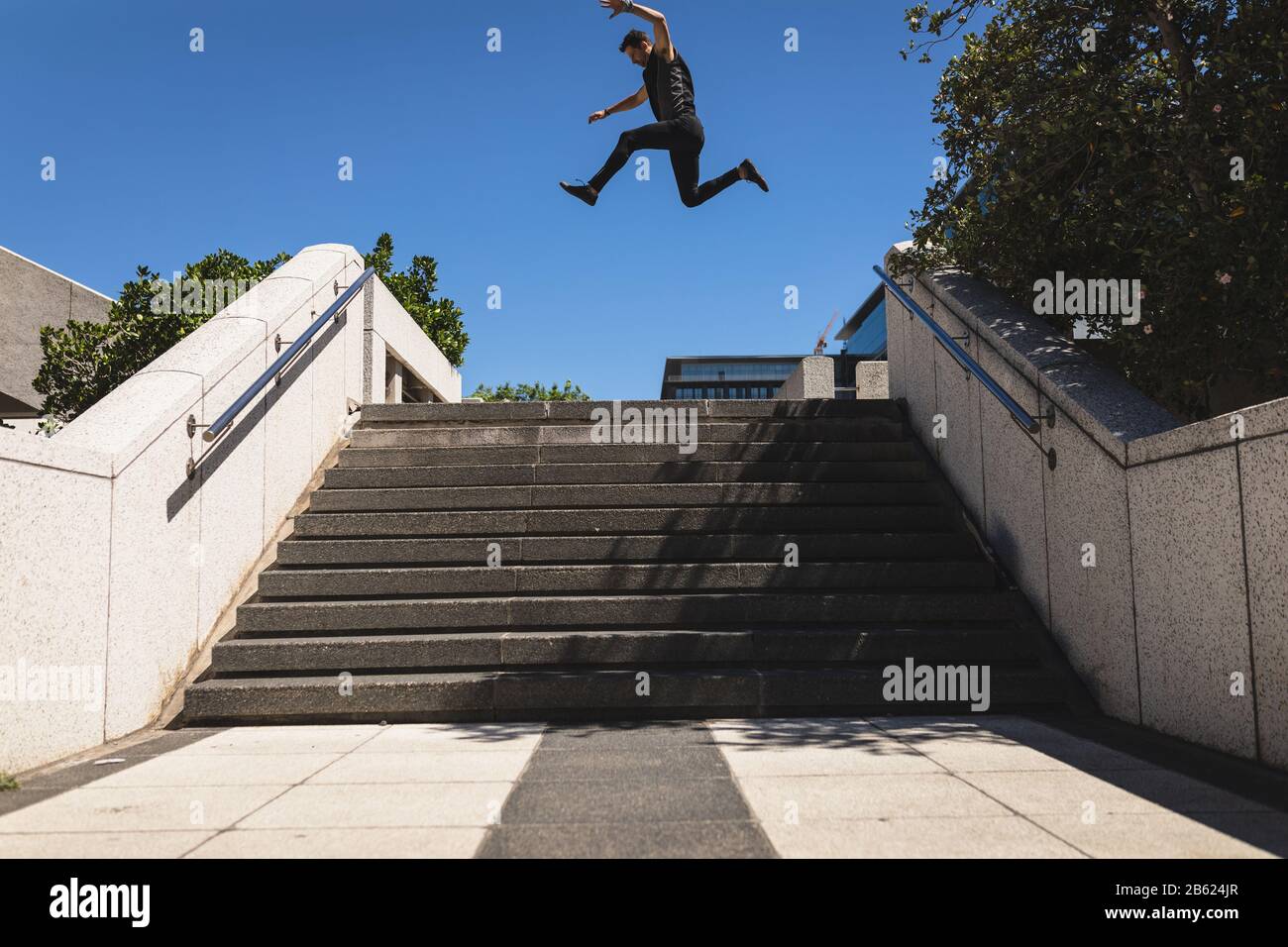 Kaukasischer Mann springt auf eine Treppe Stockfoto