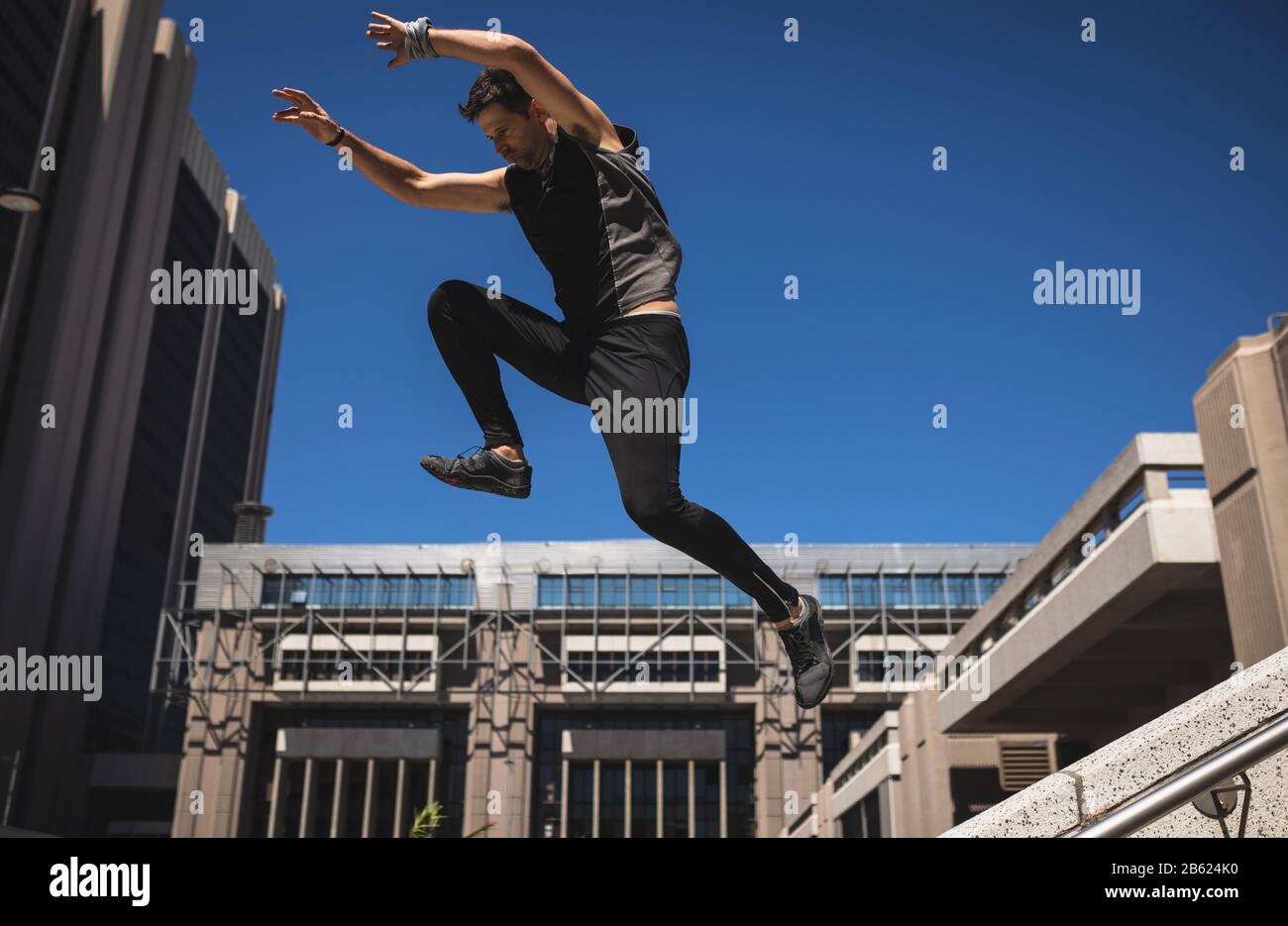 Kaukasischer Mann springt vom Gebäude Stockfoto