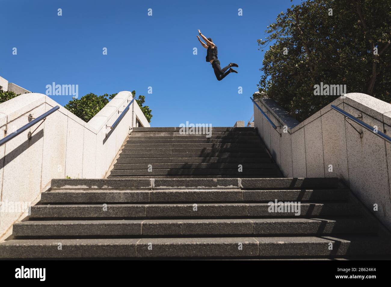 Kaukasischer Mann springt auf eine Treppe Stockfoto