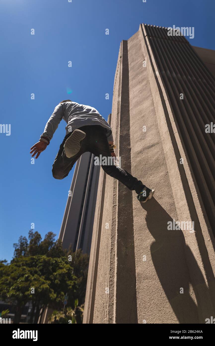 Kaukasischer Mann springt auf Gebäude Stockfoto