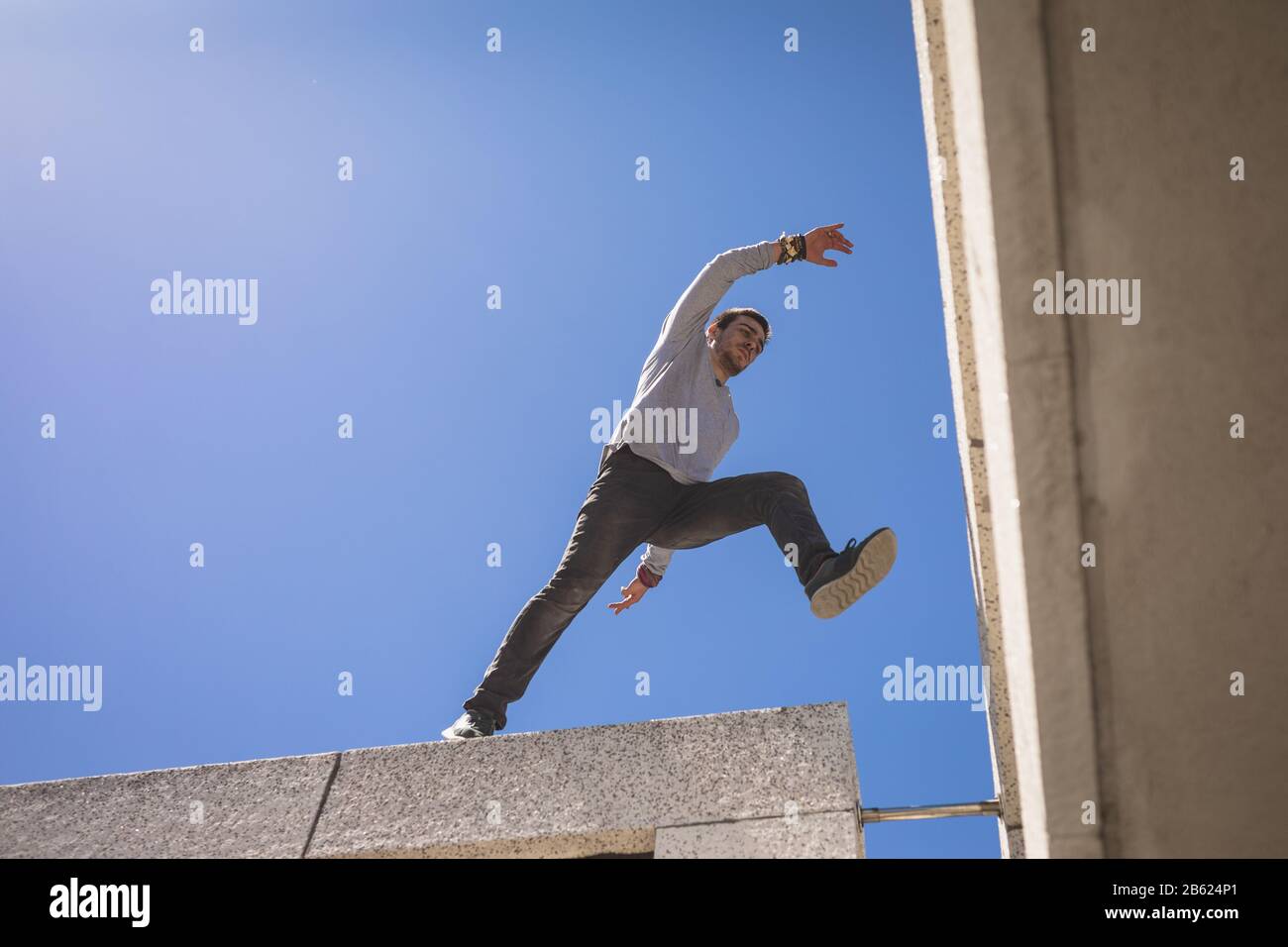 Kaukasischer Mann springt vom Gebäude Stockfoto