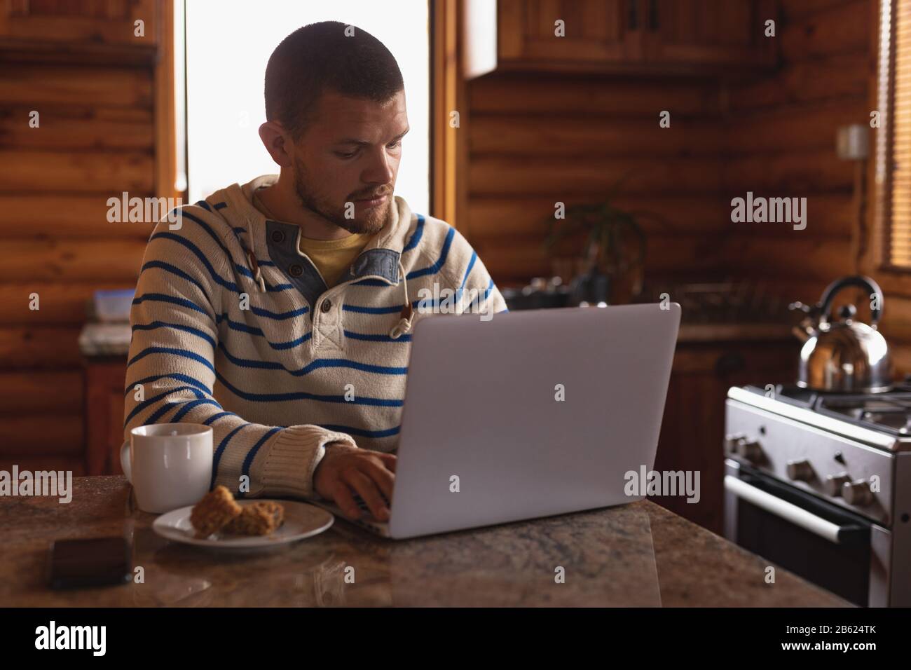 Kaukasischer Mann, der an seinem Laptop arbeitet Stockfoto