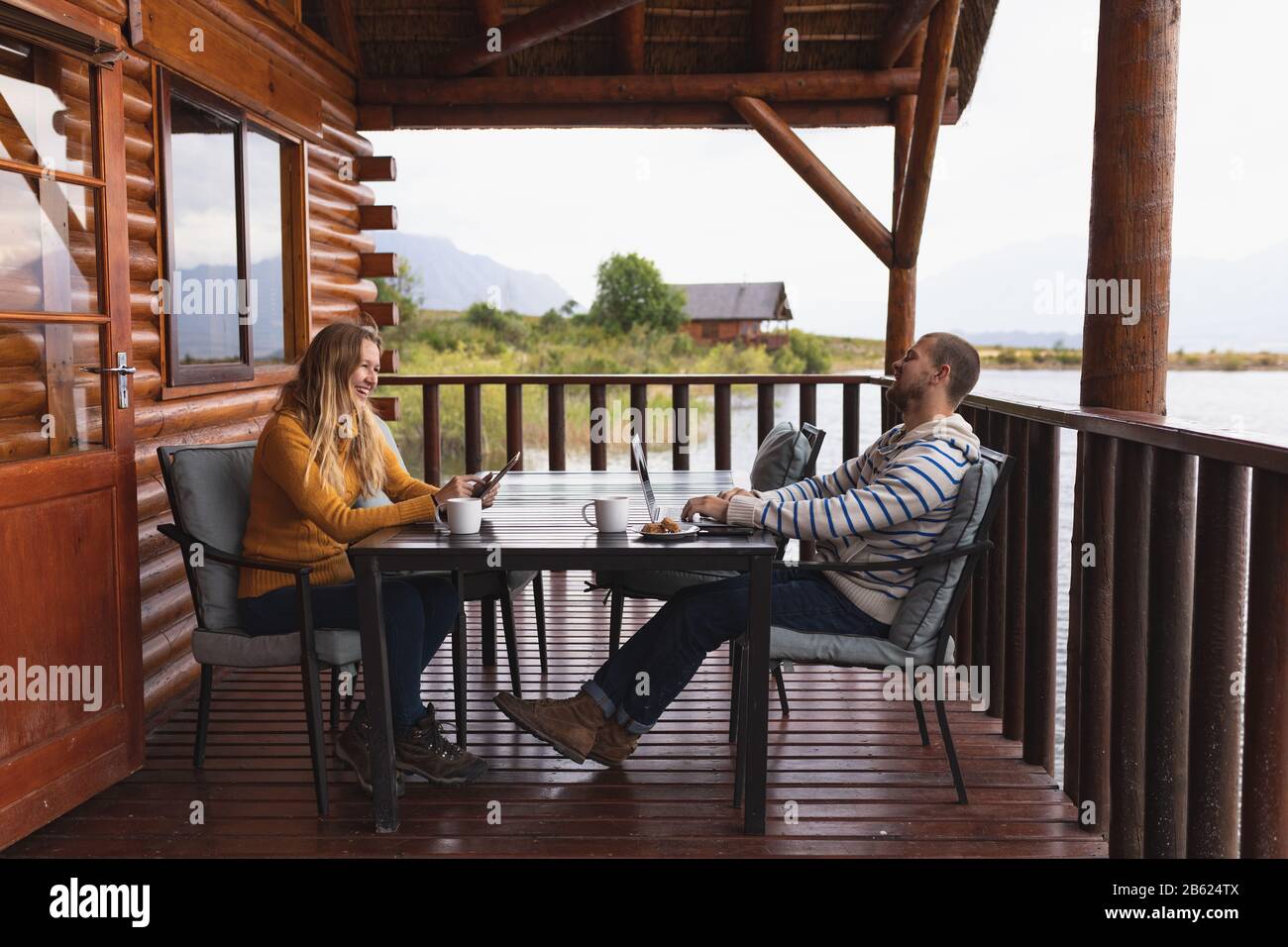 Kaukasische Paare lächeln und genießen ihren Balkon Stockfoto
