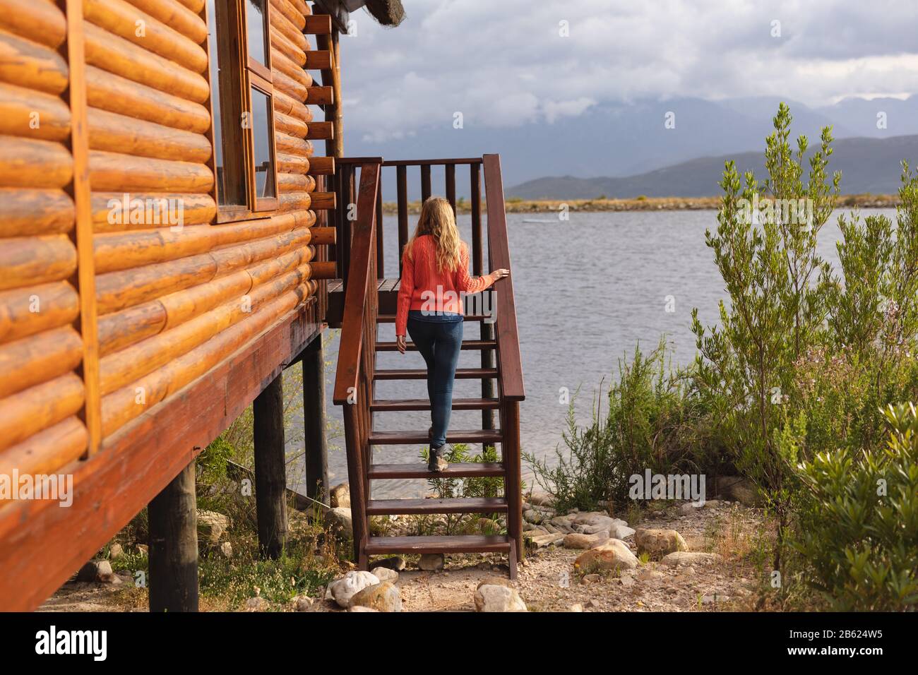 Kaukasische Frau klettert auf Treppen und bewundert ihre Heimatansicht Stockfoto