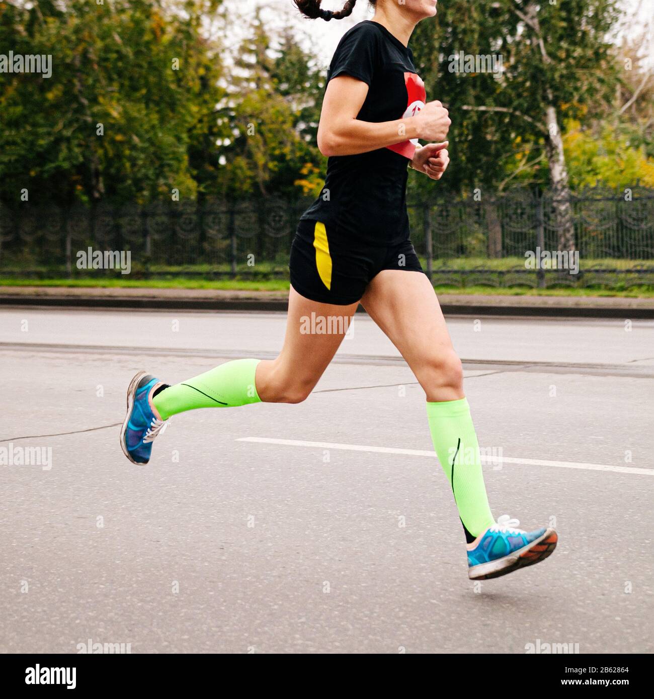 Athletin in Kompressionstrümpfe, die im Straßenmarathon laufen Stockfoto Athletin in Kompressionstrümpfe, die im Straßenmarathon laufen Stockfoto