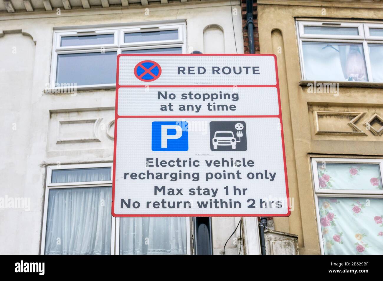 Schild mit Parkbeschränkungen an der Ladestelle für Elektrofahrzeuge an einer Bordseite im Süden Londons. Stockfoto