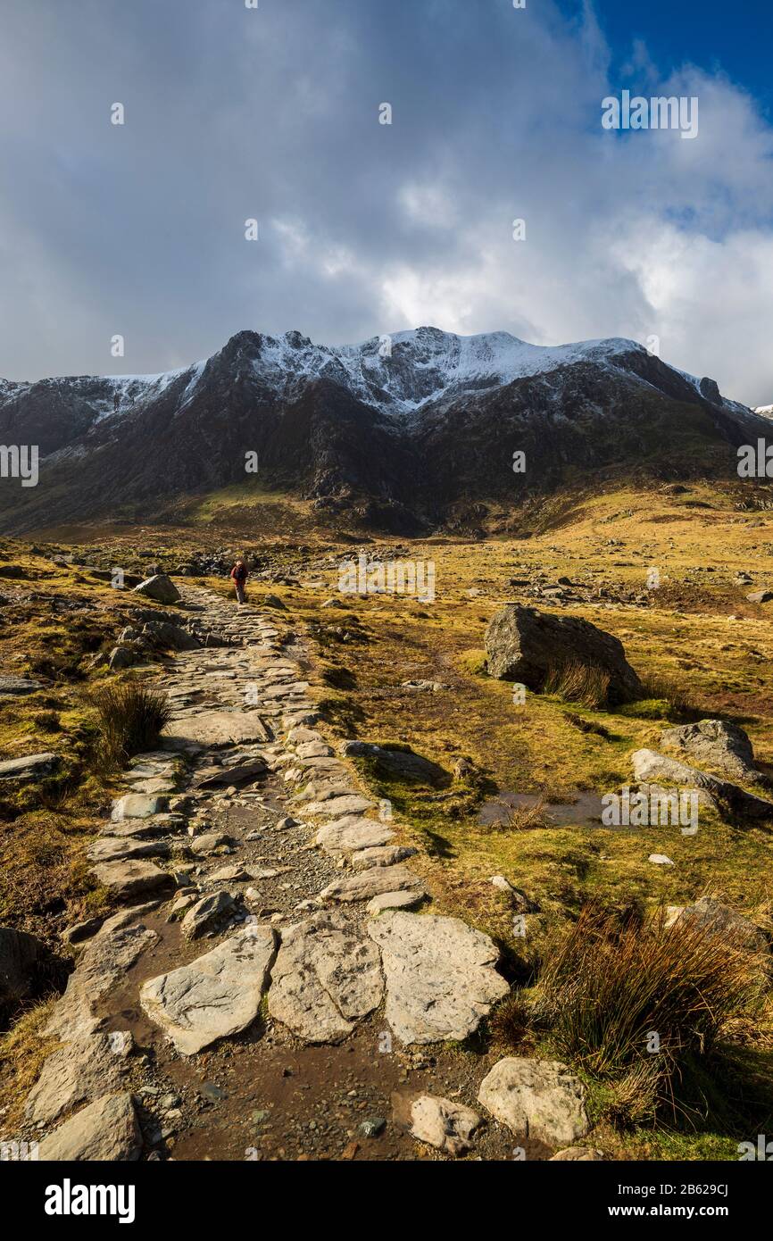 Der Steinweg, der zum Lake Idwal führt, und die schneebedeckten Berge von Snowdonia, Wales Stockfoto