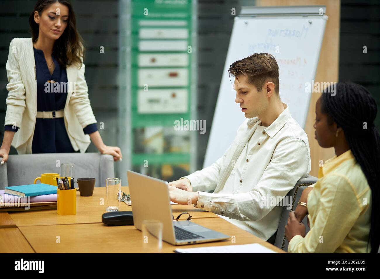 Junger blonder ernster Kerl, der Probleme mit seinen Kollegen im Bürozimmer mit modernem Interieur diskutiert. Nahansicht Foto.unangenehme Situation Stockfoto