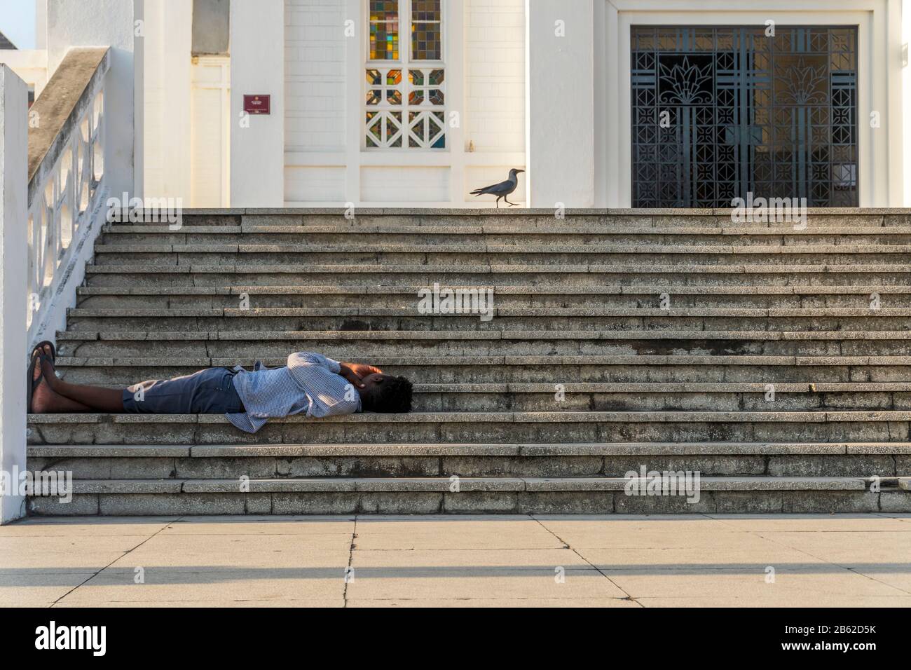 Ein Mann, der auf der Treppe vor der Kathedrale von Maputo, Mosambik, ruht Stockfoto