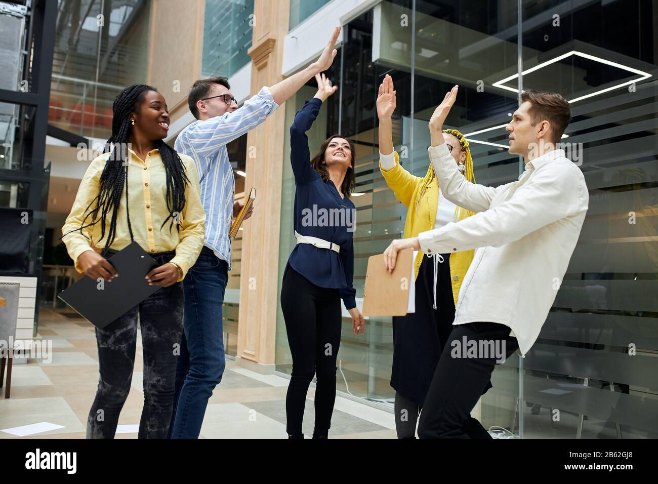 Fröhliches, ehrfürchtiges Team, das sich fünf Personen übergibt, den Sieg feiert, gewinnt, gute Arbeit, gut gemacht Stockfoto