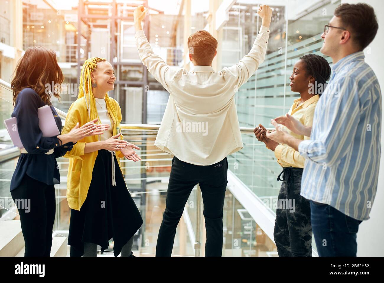 Glückliches junges Team, das ihrem Chef applaudiert, weil er einen erfolgreichen Vertrag abgeschlossen hat, Deal. Stockfoto