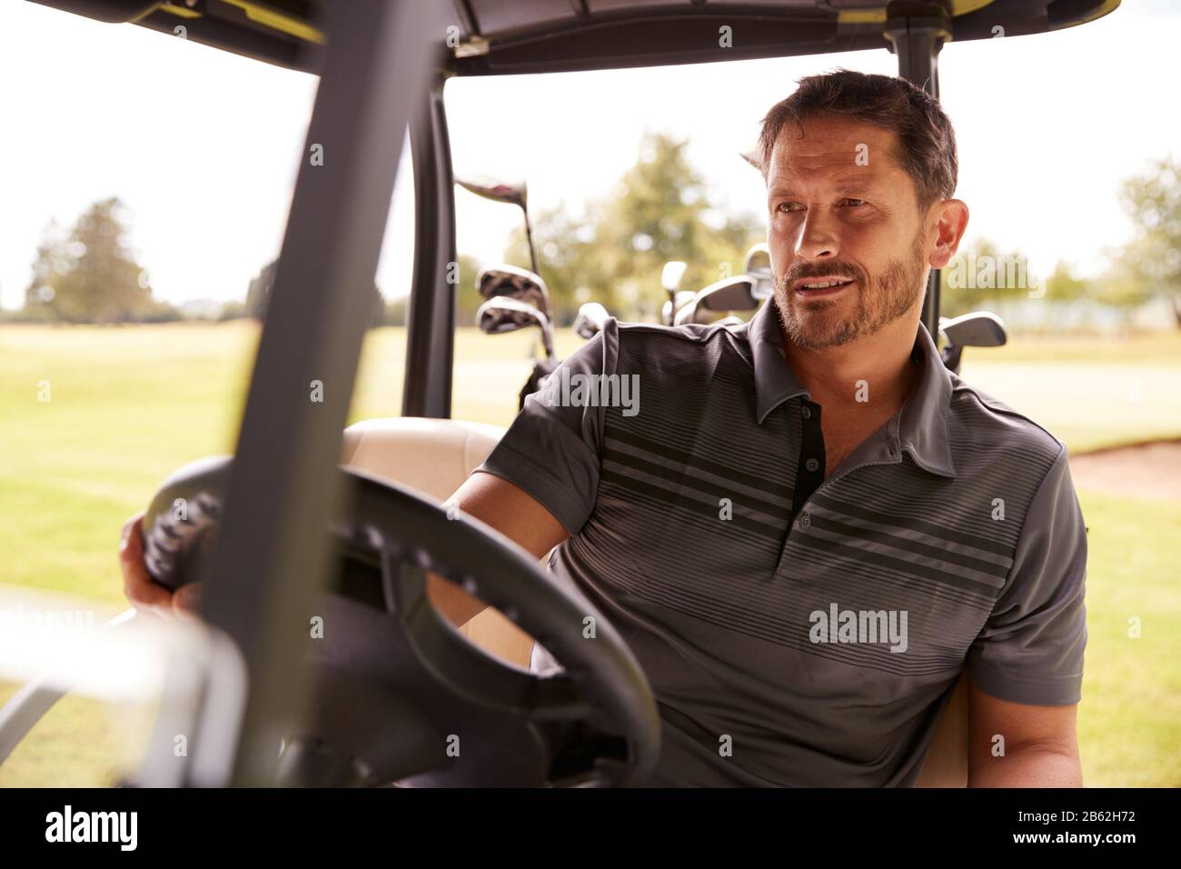 Reifer Mann, Der Golf Spielt, Der Buggy Auf Dem Kurs Nach Grün Am Red Letter Day Fährt Stockfoto