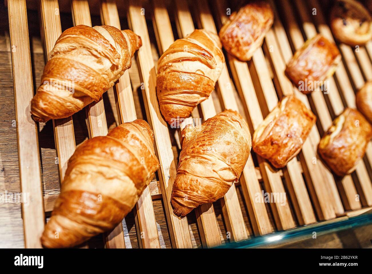 Viele Croissants auf einer Holzvitrine in einem Backwarenladen Stockfoto