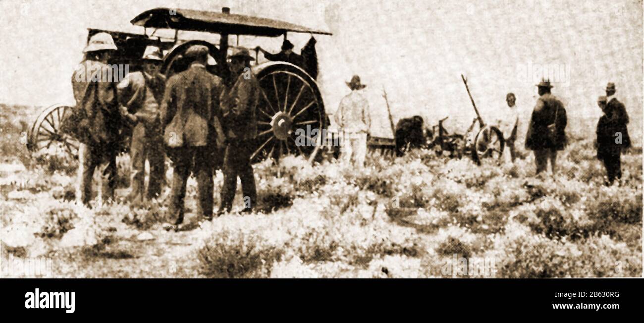 1914 - EIN seltenes Zeitungsfoto, das den Bau der Trans-Australian Railway über die Nullarbor-Ebene, Australien, zeigt. Dieses Bild zeigt Arbeiter, die mit einem Dampfpflug den Boden für die Strecke freimachen. Stockfoto