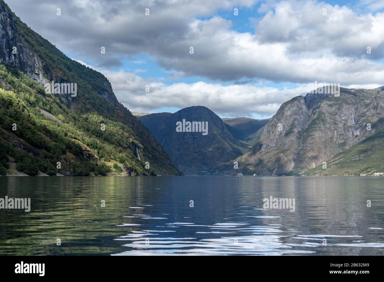 Blick von der Wasseroberfläche mit heller Reflexion. Norwegen Aurlandsfjord-Reise, Kajak-Tour. Natur, Berge, blaue Landschaft, bewölkte epische Aussicht. Stockfoto