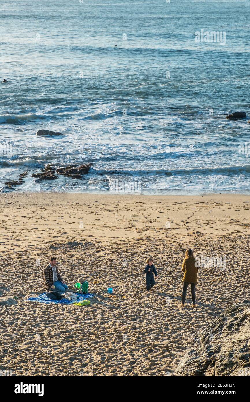 Eine junge Familie, die am Strand in Little Fistral in Newquay in Cornwall spielt. Stockfoto