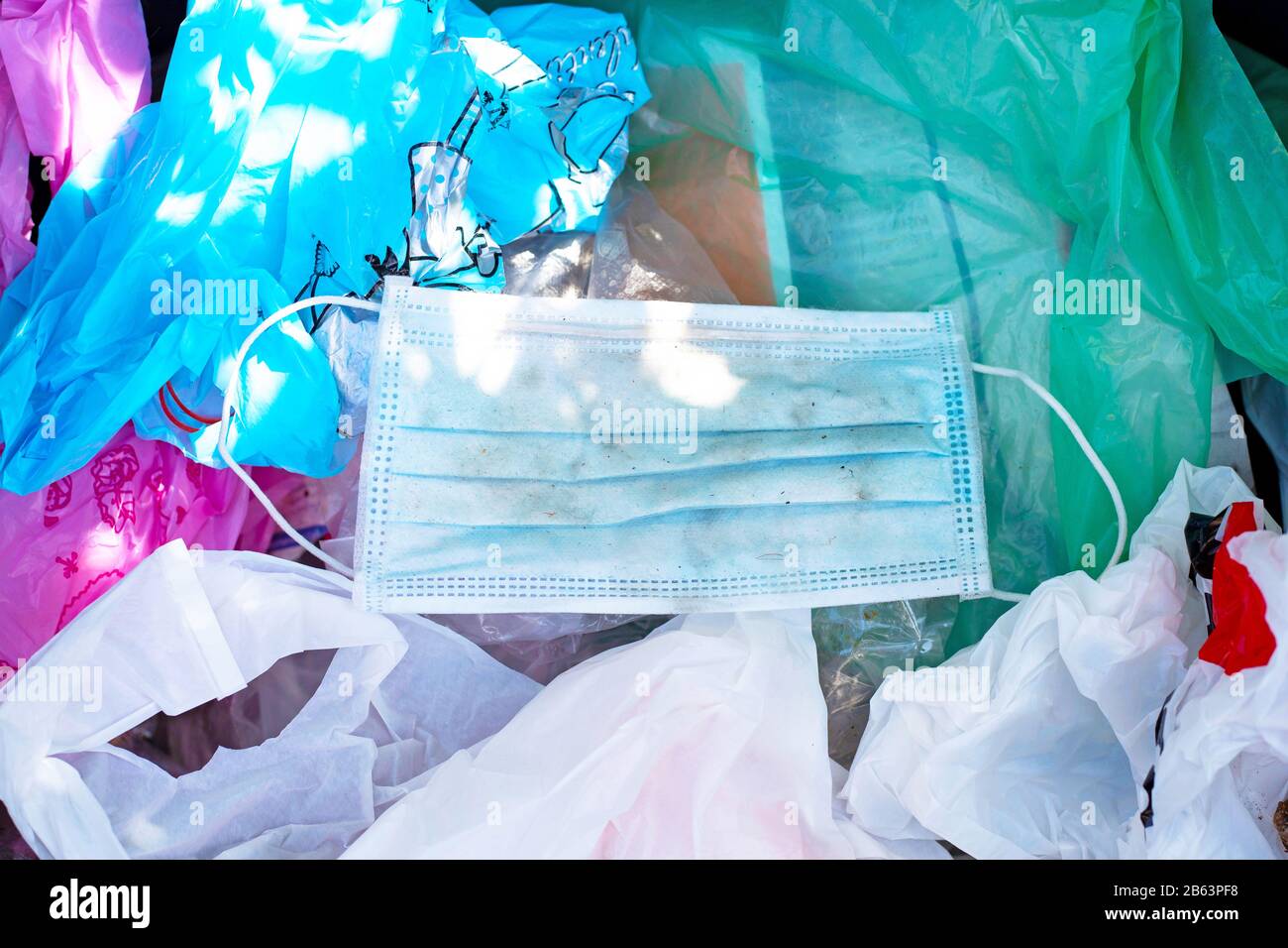 Verschmutzte gebrauchte chirurgische Maske in einem Abfallbehälter. Stockfoto