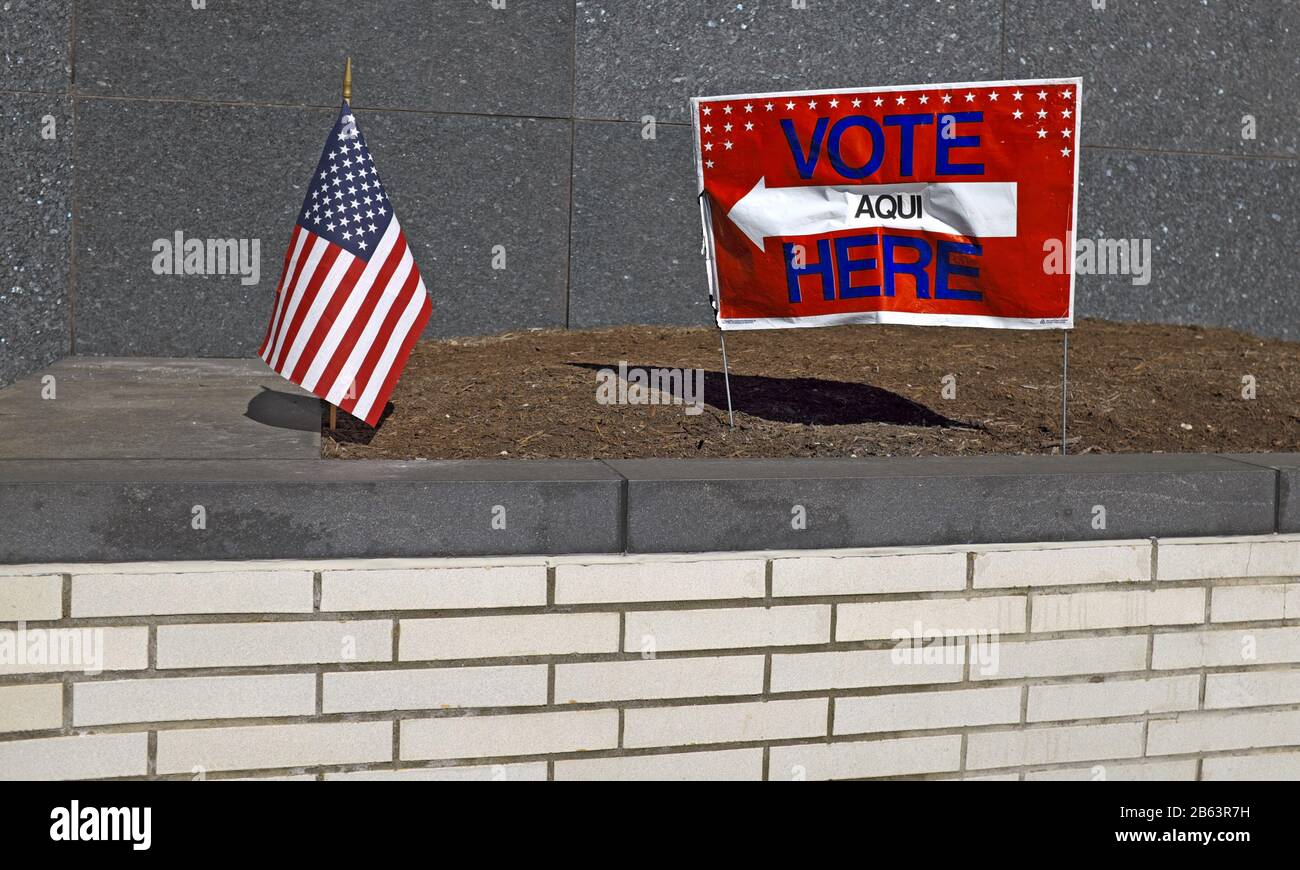 Ein "Vote Aqui Here"-Schild mit einem Pfeil in Richtung einer US-Flagge vor einem Wahllokal in Cleveland, Ohio, USA. Stockfoto