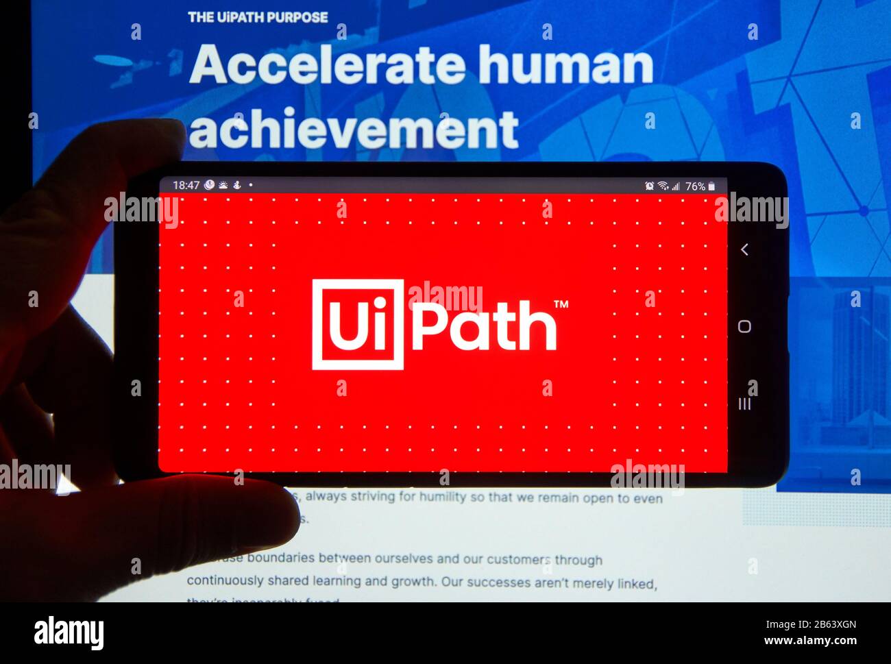 Montreal, Kanada - 08. März 2020: Eine Hand, die ein Handy mit UiPath Logo über einem Laptop-Bildschirm hält. UiPath ist ein globales Softwareunternehmen, das sich entwickelt Stockfoto